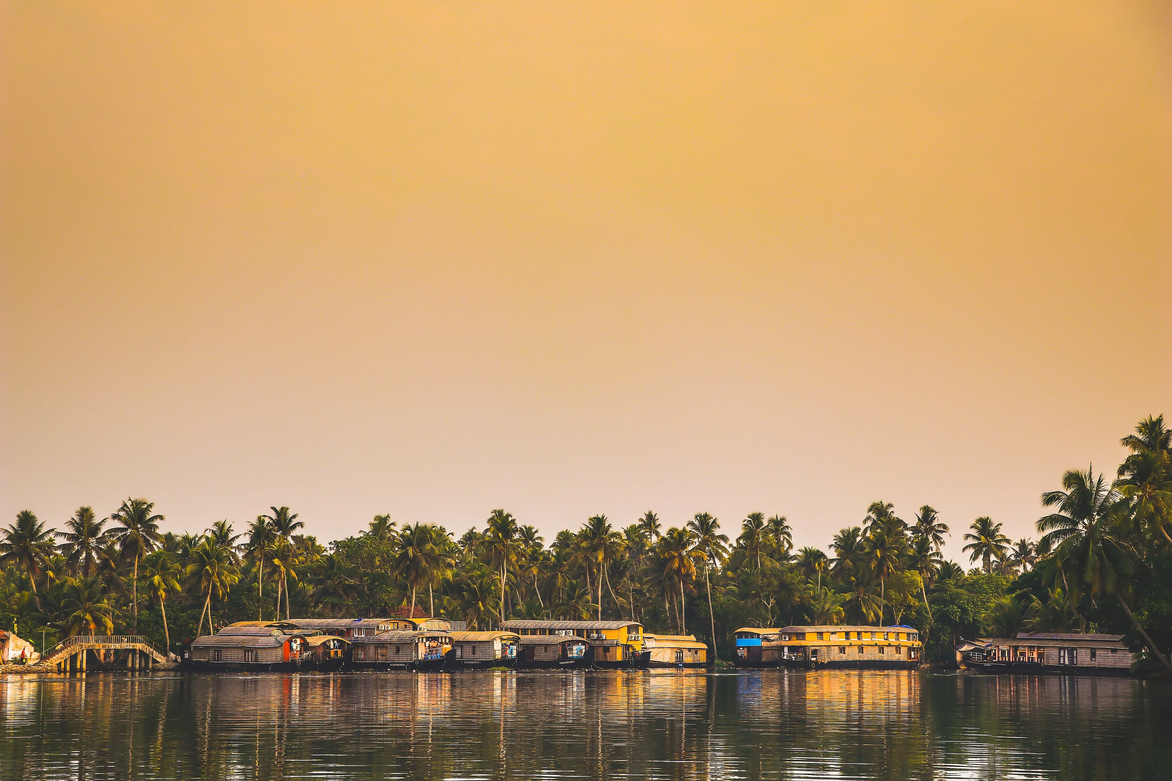 Traditional Kerala houseboat cruising the palm-lined Alleppey backwaters at golden hour